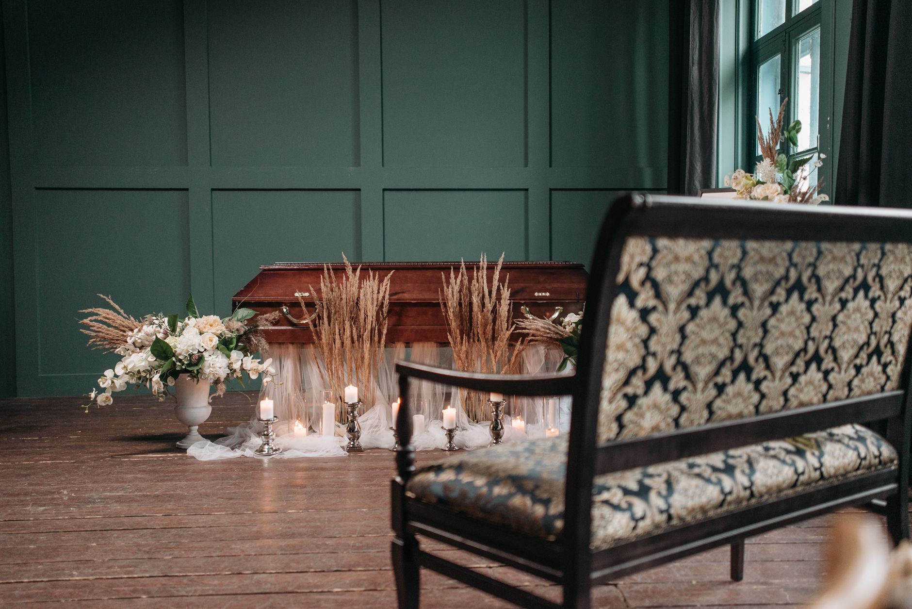 A serene funeral chapel interior with candles and flowers